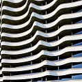 Two Modern High Rise Apartment Buildings With Wave Shaped Facade And Green Grass Field