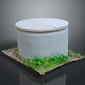 Gray Cylindrical Concrete Structure With Round Lid Surrounded By Green Grass And Dirt