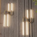 Modern Two-Light Luxury Wall Sconces with Golden Brackets and Long Tube Lights on Wooden Wall