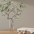 Transparent Glass Vase With Green Leaf Branches And White Flowers On Table