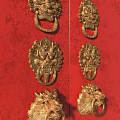 Brass Lion Head Shaped Door Knobs On Traditional Red Wooden Door