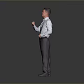 Man in light blue shirt and dark pants gesturing with right fist against gray background