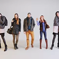 Group of Five People Wearing Winter Coats Scarves and Carrying Fashion Bags in Casual Outfits