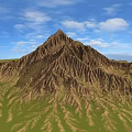 Scenic Mountain Landscape With Brown Textured Peak Green Grassy Fields And Blue Sky White Clouds