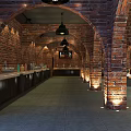 Interior Of Exhibition Hall With Red Brick Arches Black Pendant Lights And Porcelain Displays