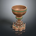 Ornate Golden Cup With Green Gemstone Embellishments And Intricate Pedestal Base