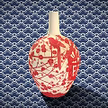 Ceramic Vessel With Red And White Plum Blossom Bird Design Against Blue Wave Pattern Background