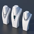 Elegant Jewelry Necklaces On White Display Stands With Layered Chains And Green Pendant