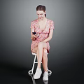 Woman Sitting On Chair In Floral Dress Using Smartphone With White Sneakers And Gray Background