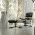 Modern Black Leather Lounge Chair With Wooden Armrests By Window In Natural Light