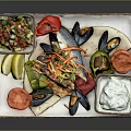 Delicious Fresh Seafood Platter With Prawns Mussels Tomatoes Lemon Slices And Yogurt Dip