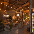 Industrial Style Cafe Interior With String Lights Wooden Tables Plants And Beverage Cooler