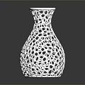 Green Plants In White Perforated Vase With Hollow Out Design On Black Surface