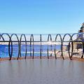 Seaside Viewing Platform With Transparent Curved Railings Blue Sea And Distant Building