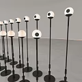 Art Installation With Neatly Arranged Black Bases Silver Spherical Tops Woman In Gray Space