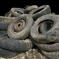 Old Worn Tires Piled High Outdoors on Dirt Ground