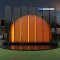 Outdoor Stage Setup With Orange Circular Structure Glass Curtain Wall And Lighting Equipment At Sunset
