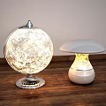 Globe And Mushroom Shaped Table Lamps On Wooden Table With Warm Illumination