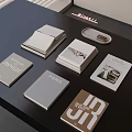 Various Designed Books Magazines On Black Tabletop With Decorative Tray And Artistic Covers