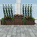 Decorative Garden Planters With Tall Green Plants Pink Flowers Against White Fence Stone Pavement