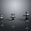 Three Different Sizes Cat Figurines In Black White Spots With Green Eyes On Gray Background