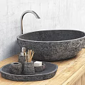 Black Stone Sink with Silver Faucet on Wooden Countertop and Stone Containers Against Gray Wall