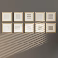 Modern Abstract Paintings with Golden Frames on Gray Wall and Diagonal Light Shadows