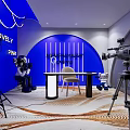 Public Office Space Featuring Blue Walls Desk with Chair Camera Lighting Equipment and Robot Figures