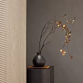 Black Textured Vase With Golden Leaf Branches On Square Wooden Stand Against Grey Wall