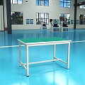 Industrial Equipment Workbench With Green Top And Lamp In Modern Factory Workshop