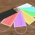 Various Colored Disposable Face Masks With Ear Loops On Wooden Background