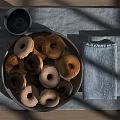 Assorted Donuts On Gray Plate With Gray Cup And Light Blue Cloth On Wooden Table