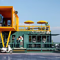 Yellow And Green Container Building Coffee Shop With Staircase Outdoor Umbrellas And Benches