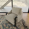 Light Beige Single Sofa With Black Wooden Arms On Patterned Rug And Wooden Floor
