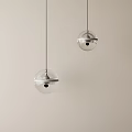 Two Transparent Glass Globe Pendant Lights Hanging With Metal Ring On Light Colored Background