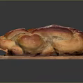 Golden Brown Braided Bread On Wooden Cutting Board With Glossy Finish