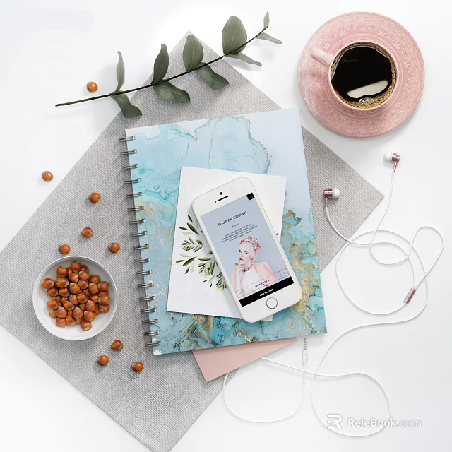 Artistic Notebook on Desk With Smartphone Earphones Hazelnuts Coffee Cup And Green Leaves 3d model 