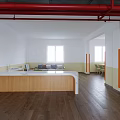 Bright Dining Room Interior With Long Tables Green Chairs Orange Pillars Wooden Flooring And Posters