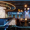 Modern Bar Interior with Colorful Spherical Pendant Lights Stage Tables Chairs and Lighting Effects