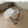 Round Glass Top Coffee Table With Black Metal Base And Modern Design Book