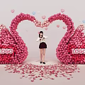 Girl Standing Under Pink Swan Balloon Arch With Heart Decorations And Petals