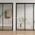 Minimalist Interior Featuring Black Framed Glass Sliding Doors Indoor Plants And Stuffed Toy