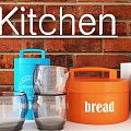 White Kitchen Cabinets With Red Brick Wall Cooking Tools Plants And Magazines On Countertop