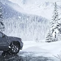 Stunning Snow Covered Mountain Pine Forest Winter Landscape With SUV Parked On Icy Snowy Road