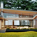 Modern Single Family House With Large Glass Windows Surrounded by Green Trees and Lawn