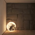 Moon Shaped Illuminated Floor Lamp In Modern Room With Stone Wall And Wooden Floor