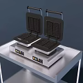 Two Black Waffle Makers As Kitchen Appliances On Metal Table 3d model