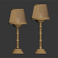 Two Gold Table Lamps With Mesh Shades Bamboo Poles And Textured Bases On Black Background