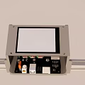 Industrial Equipment Control Panel With Display Screen Mounted On Metal Rail And Internal Electronic Components