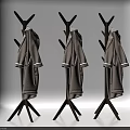 Light Gray Coats With White Cuffs Hanging On Three Wooden Coat Racks